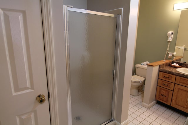 bathroom with toilet, vanity, tile patterned flooring, and a shower with door