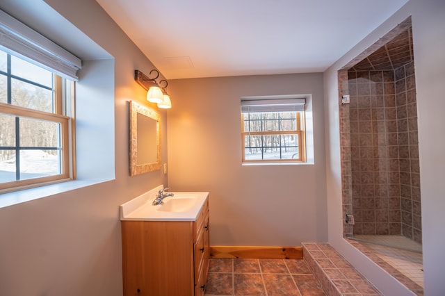 bathroom featuring a tile shower and vanity