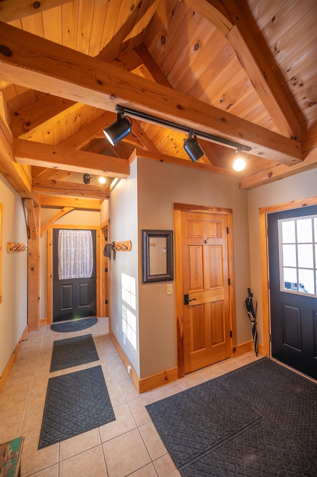 entryway with wooden ceiling, rail lighting, lofted ceiling with beams, and light tile patterned flooring