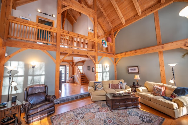 living room featuring high vaulted ceiling, light hardwood / wood-style flooring, beam ceiling, and wood ceiling