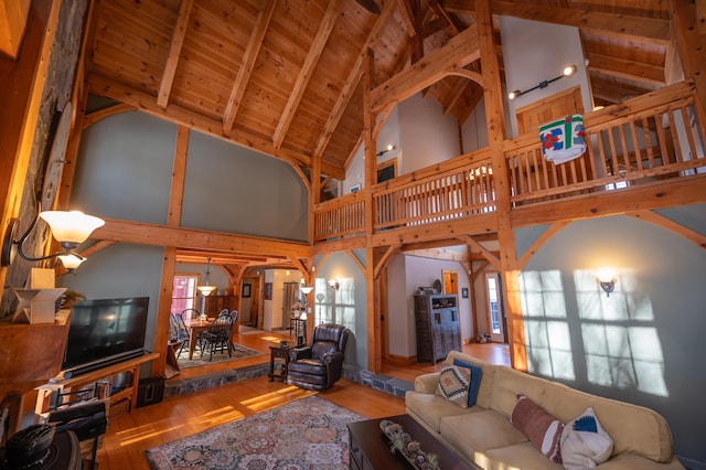 living room featuring high vaulted ceiling, hardwood / wood-style floors, beamed ceiling, and wooden ceiling