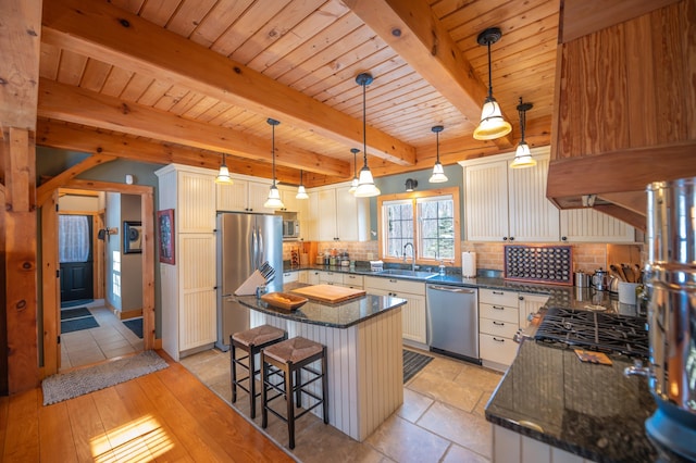 kitchen featuring hanging light fixtures, white cabinets, appliances with stainless steel finishes, and a center island