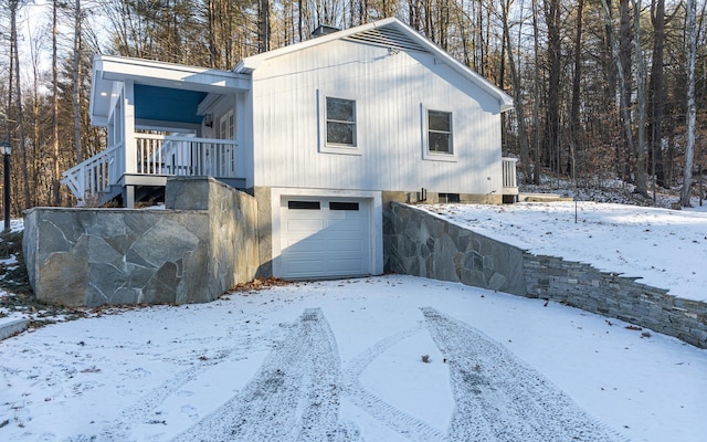 snow covered property with a garage