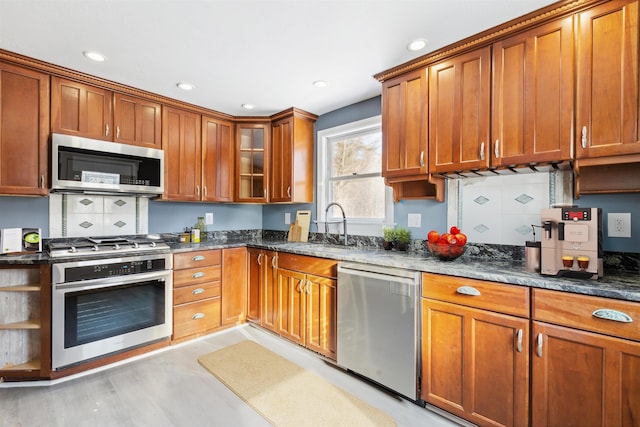 kitchen featuring dark stone counters, sink, and stainless steel appliances