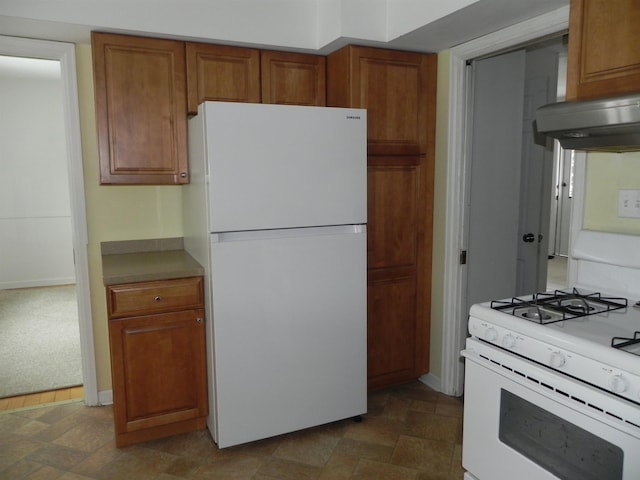 kitchen with white appliances, ventilation hood, and dark colored carpet