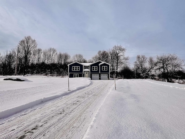 yard layered in snow featuring a garage