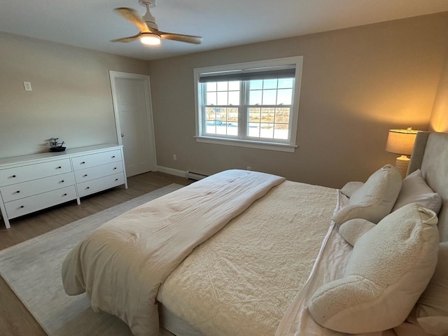 bedroom with ceiling fan, baseboard heating, and dark hardwood / wood-style floors