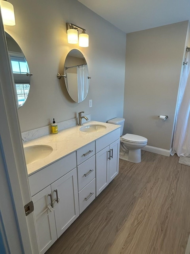 bathroom featuring toilet, vanity, curtained shower, and hardwood / wood-style floors