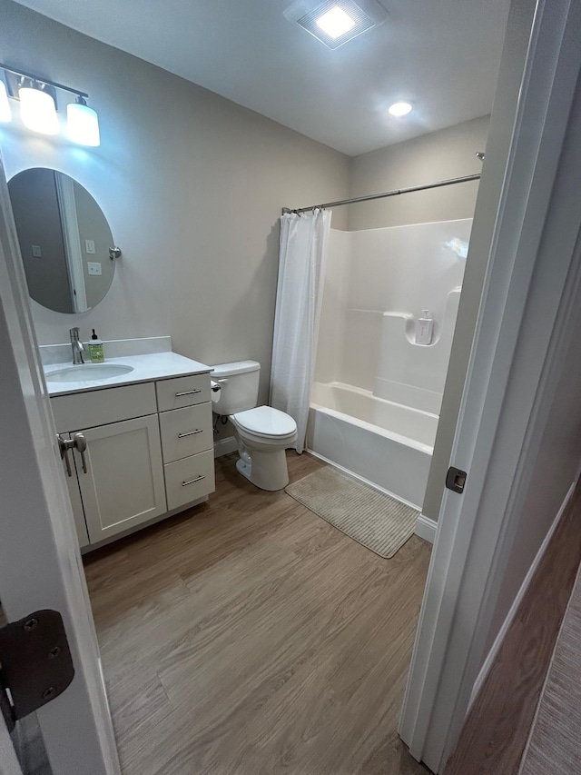 full bathroom featuring hardwood / wood-style flooring, toilet, vanity, and shower / bathtub combination with curtain