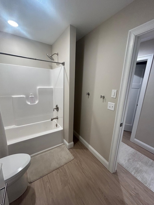 bathroom with toilet, shower / bath combination, and hardwood / wood-style flooring