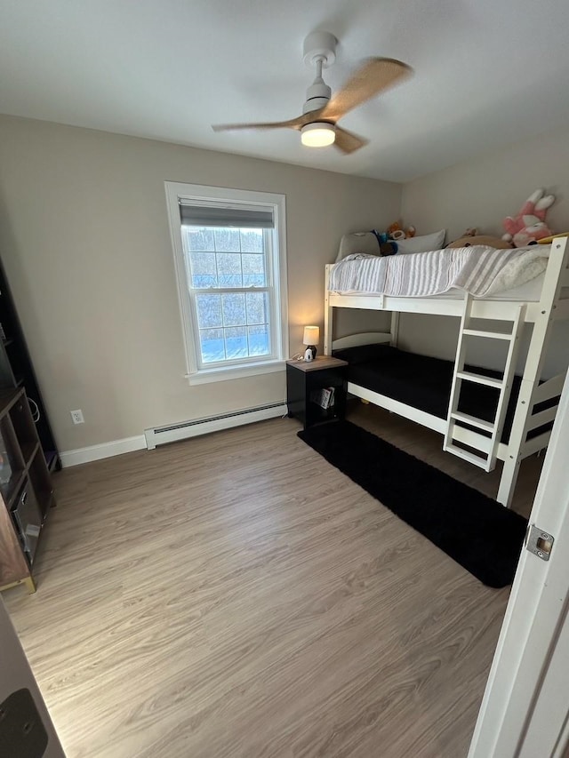 bedroom with ceiling fan, baseboard heating, and light hardwood / wood-style floors