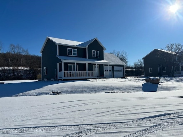 snow covered property with a porch and a garage