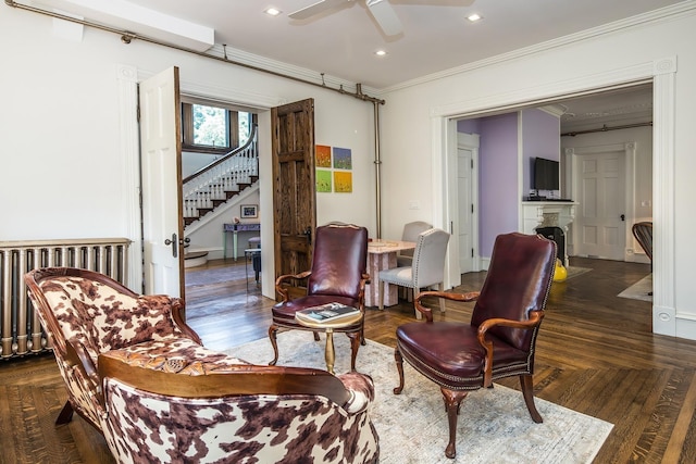 living area featuring ceiling fan, radiator, dark hardwood / wood-style floors, and ornamental molding