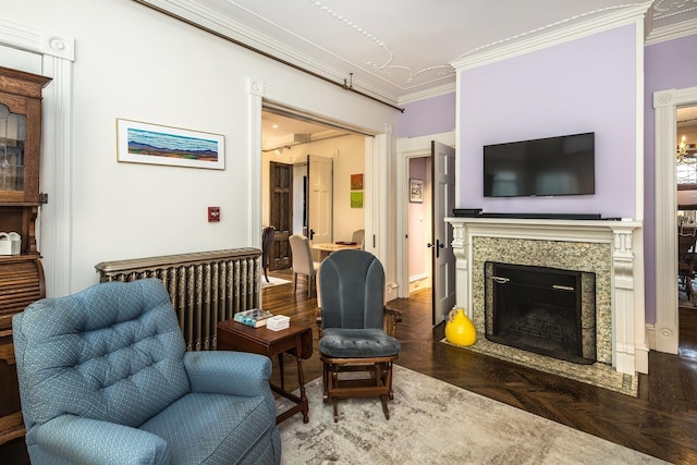 sitting room featuring parquet flooring, a fireplace, and ornamental molding