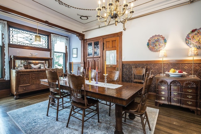 dining space featuring dark wood-type flooring, crown molding, and a chandelier