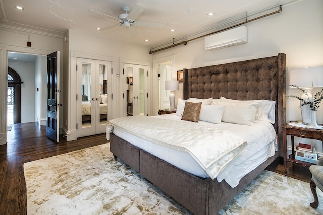 bedroom featuring dark hardwood / wood-style flooring, a wall mounted AC, ceiling fan, crown molding, and multiple closets