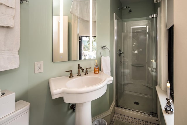 bathroom featuring tile patterned floors, toilet, and an enclosed shower