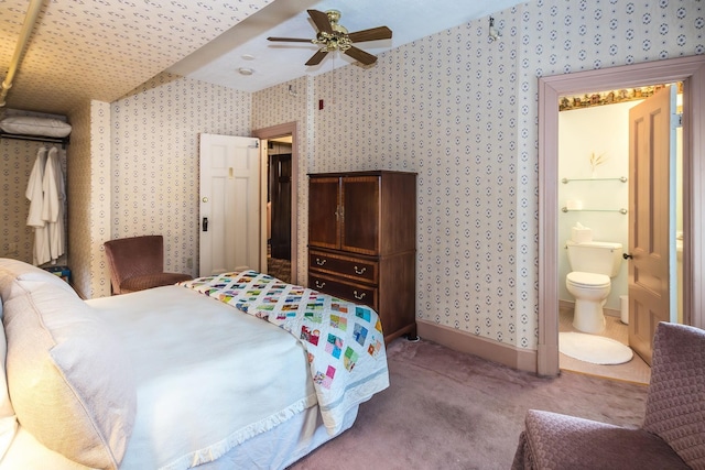 bedroom with ceiling fan, carpet, and ensuite bathroom