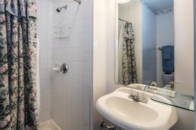 bathroom featuring a shower with shower curtain and sink