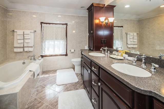 bathroom featuring tile walls, toilet, vanity, and tiled tub