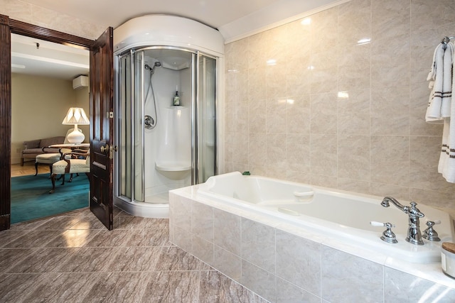 bathroom featuring shower with separate bathtub, an AC wall unit, and tile walls