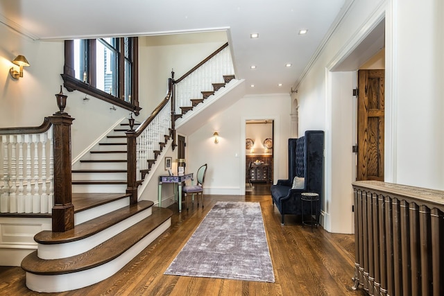 staircase featuring hardwood / wood-style flooring, radiator heating unit, and ornamental molding