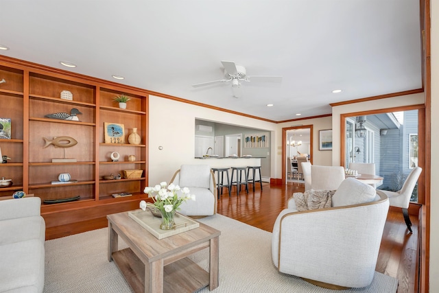 living room with ceiling fan, ornamental molding, and light hardwood / wood-style flooring