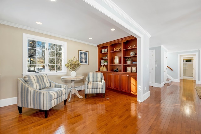 sitting room with wood-type flooring, ornamental molding, and a baseboard radiator