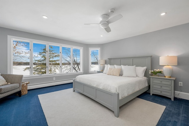 bedroom with a baseboard heating unit, ceiling fan, and dark colored carpet