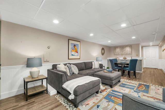 living room with a paneled ceiling and hardwood / wood-style floors