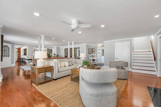 living room featuring ceiling fan, crown molding, light hardwood / wood-style flooring, and ornate columns