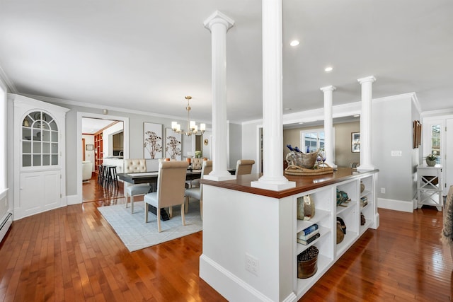 kitchen with ornate columns, a chandelier, and ornamental molding