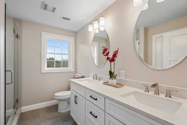 bathroom featuring tile patterned flooring, toilet, a shower with door, and vanity