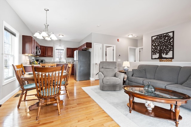 living room featuring an inviting chandelier and light wood-type flooring