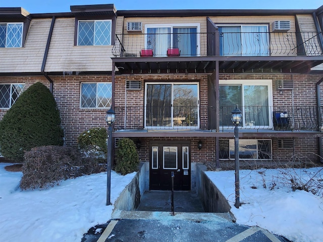 snow covered rear of property featuring a balcony