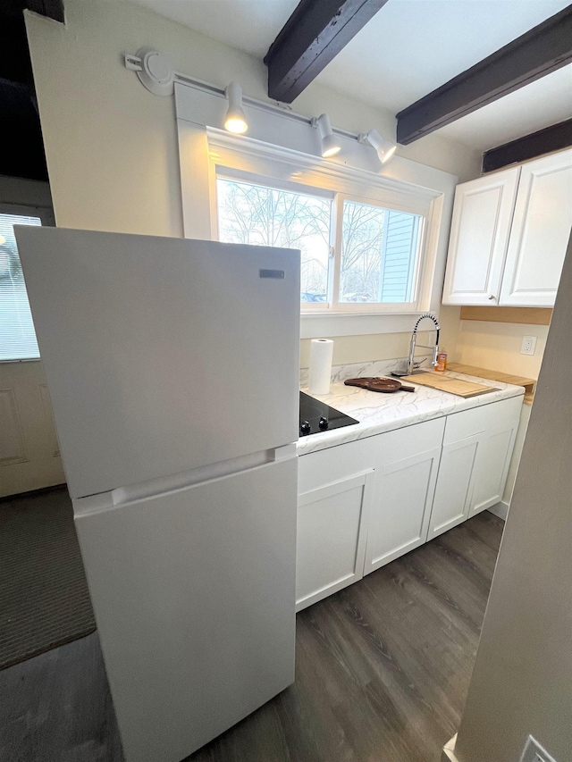 kitchen featuring white cabinetry, beamed ceiling, dark wood-type flooring, white refrigerator, and sink