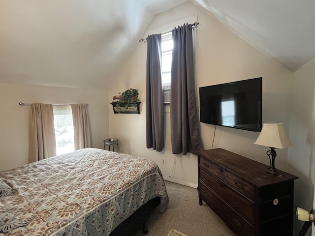 bedroom with lofted ceiling and light colored carpet