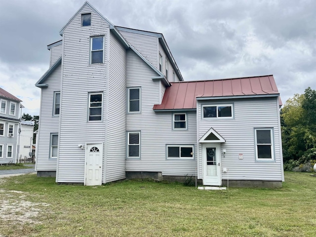 rear view of property featuring a lawn