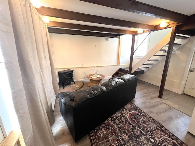 basement with a wood stove and hardwood / wood-style flooring