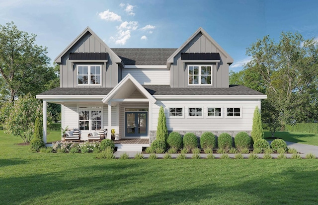 view of front of property featuring a front lawn, french doors, and covered porch