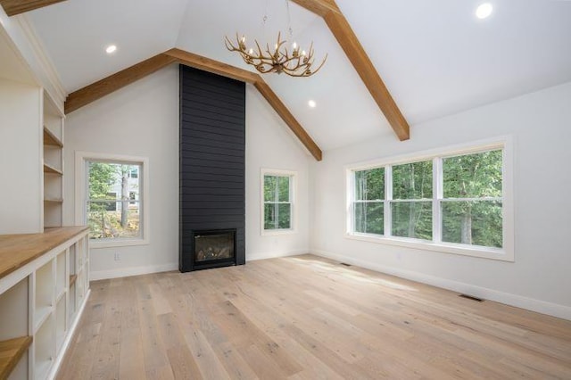 unfurnished living room with a large fireplace, a chandelier, light wood-type flooring, high vaulted ceiling, and beam ceiling