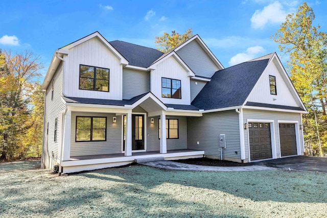 modern farmhouse with a front yard, a garage, and a porch