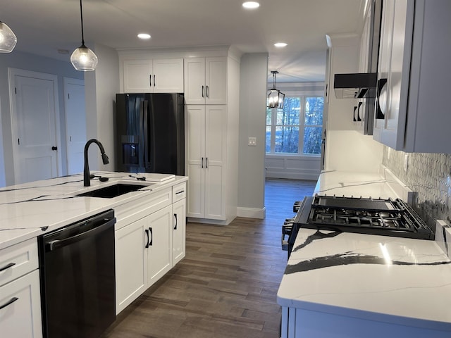 kitchen with black appliances, sink, white cabinetry, and pendant lighting