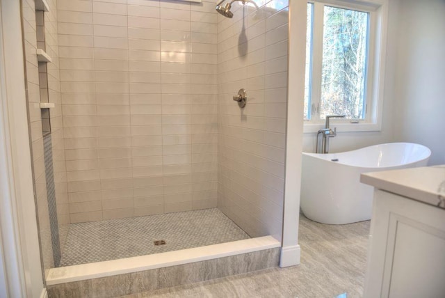 bathroom featuring vanity and shower with separate bathtub