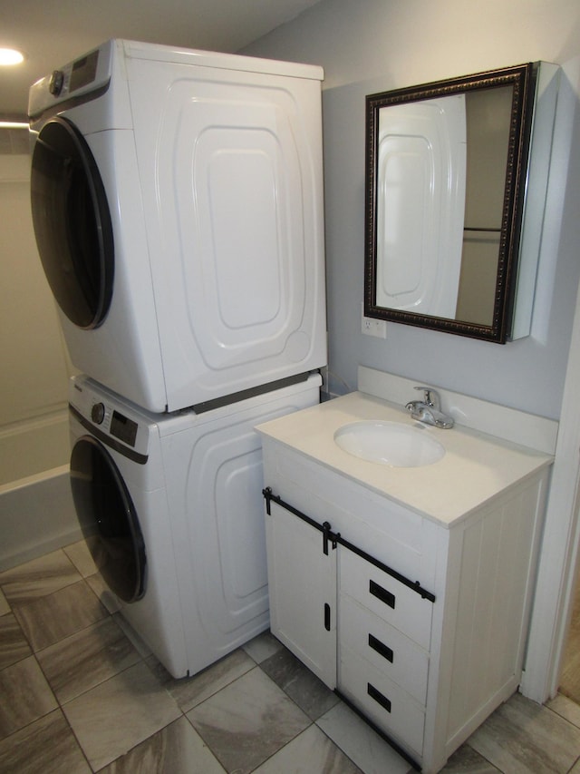 clothes washing area with stacked washer / drying machine and sink