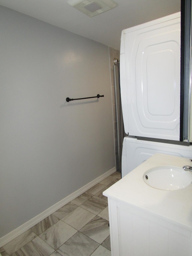 bathroom with vanity and stacked washer and dryer