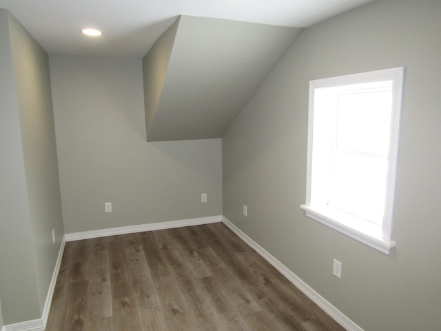 bonus room with lofted ceiling and dark wood-type flooring