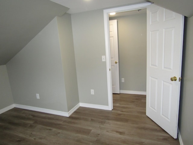 additional living space with dark hardwood / wood-style flooring and lofted ceiling