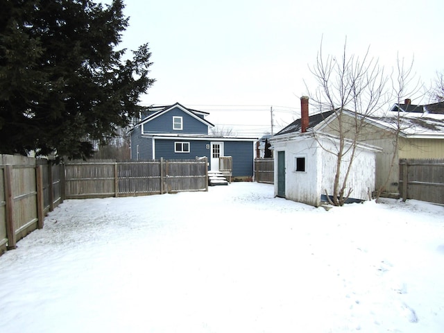 yard layered in snow featuring a shed