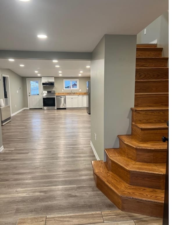 stairs with sink and wood-type flooring